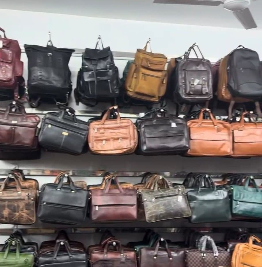 Leather backpacks and laptop bags in black, tan and brown displayed on shelves